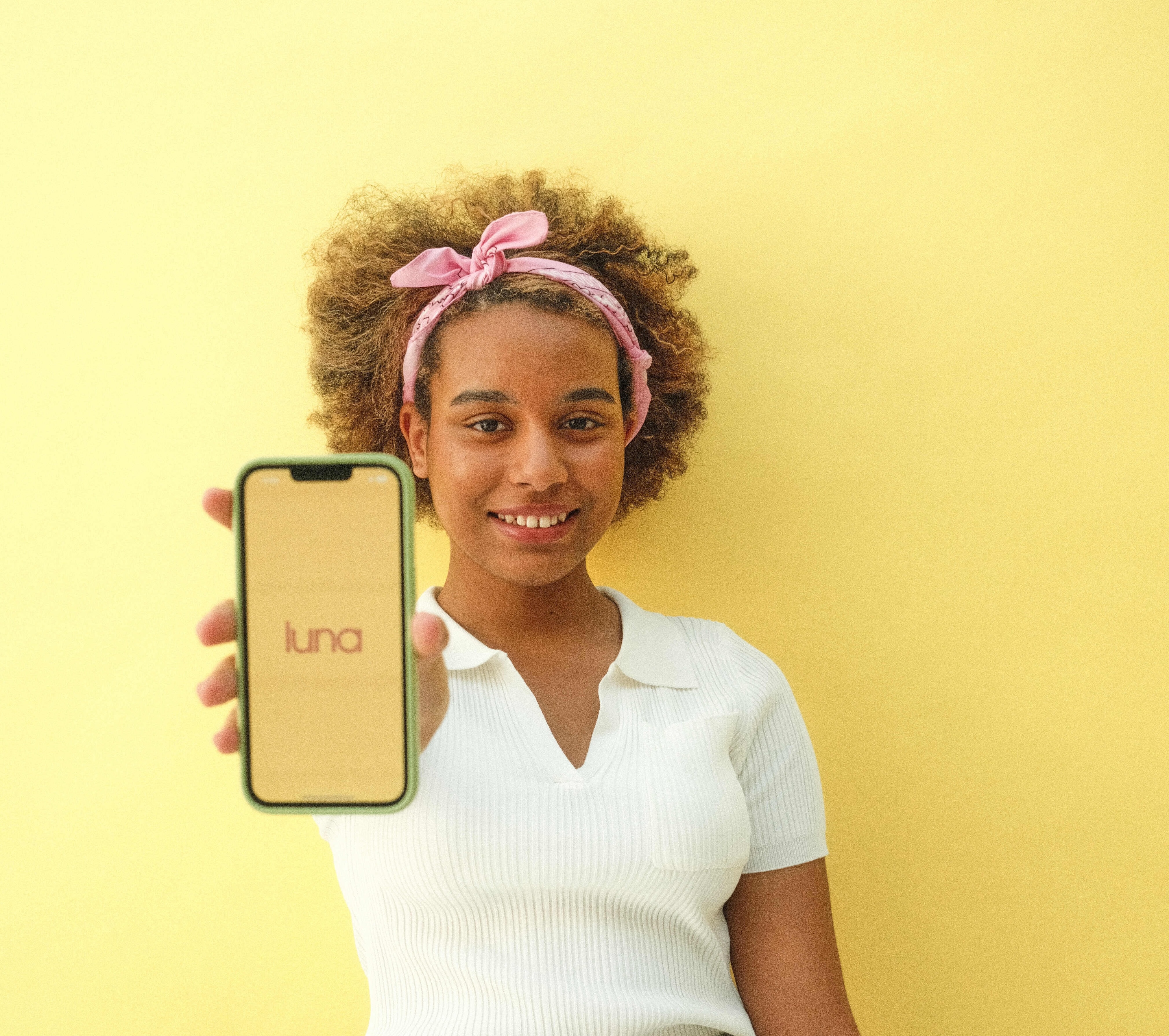 a girl holding a phone up with the luna logo on it